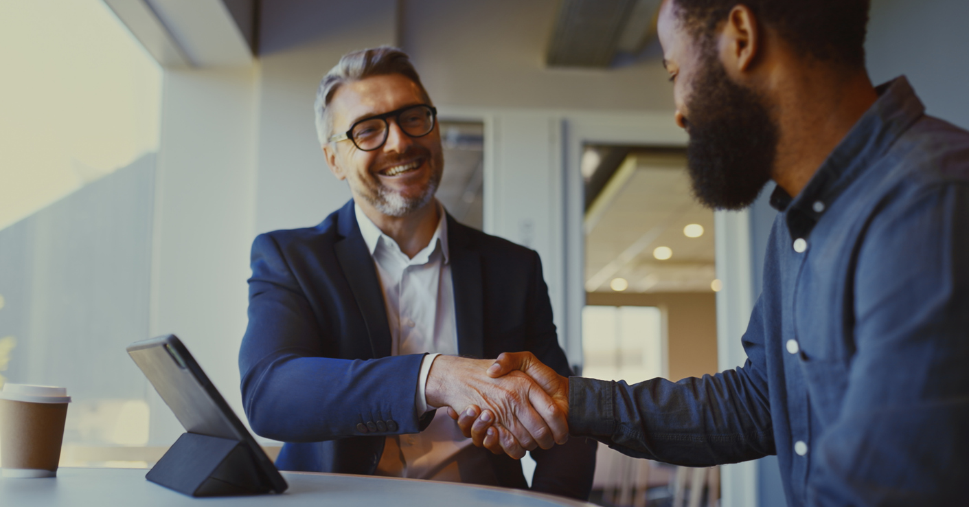 Two gentleman shake hands.
