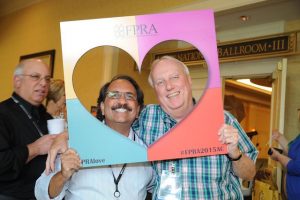 FPRA annual conference, two member posing with cardboard poster with heart cutout labeled #FPRAlove