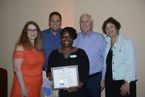 FPRA members posing with the recipient of an award plaque