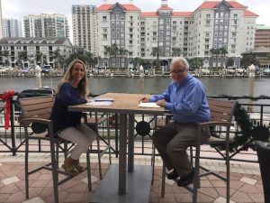 Two FPRA members seated at an outdoor café table smiling at the camera