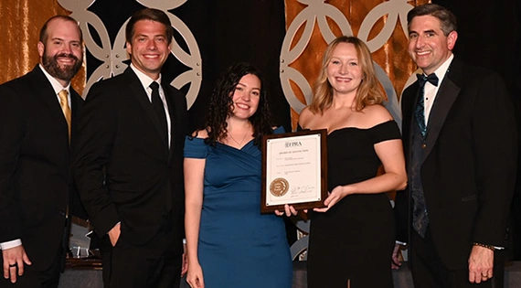Five FPRA members in formal attire posing together with an award